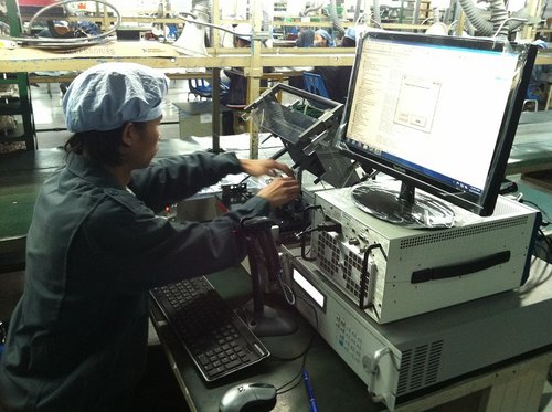 Technician running an automated "bed-of-nails" FCT Station