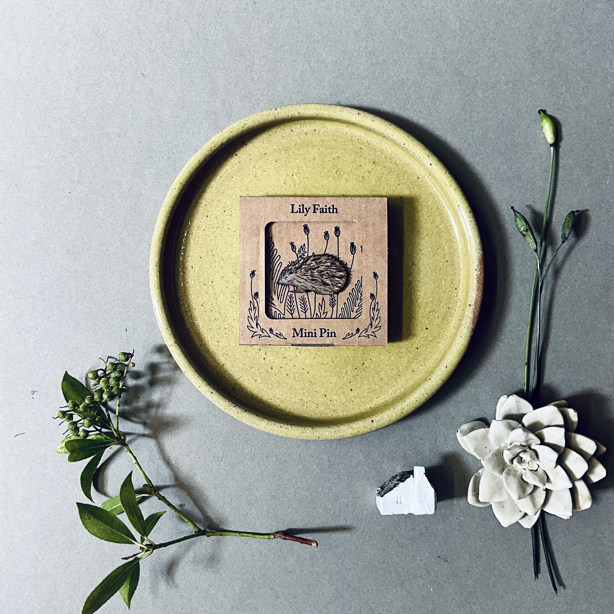 A laser cut MDF Hedgehog brooch, hand painted with gouache and chalk paint and Indian ink.