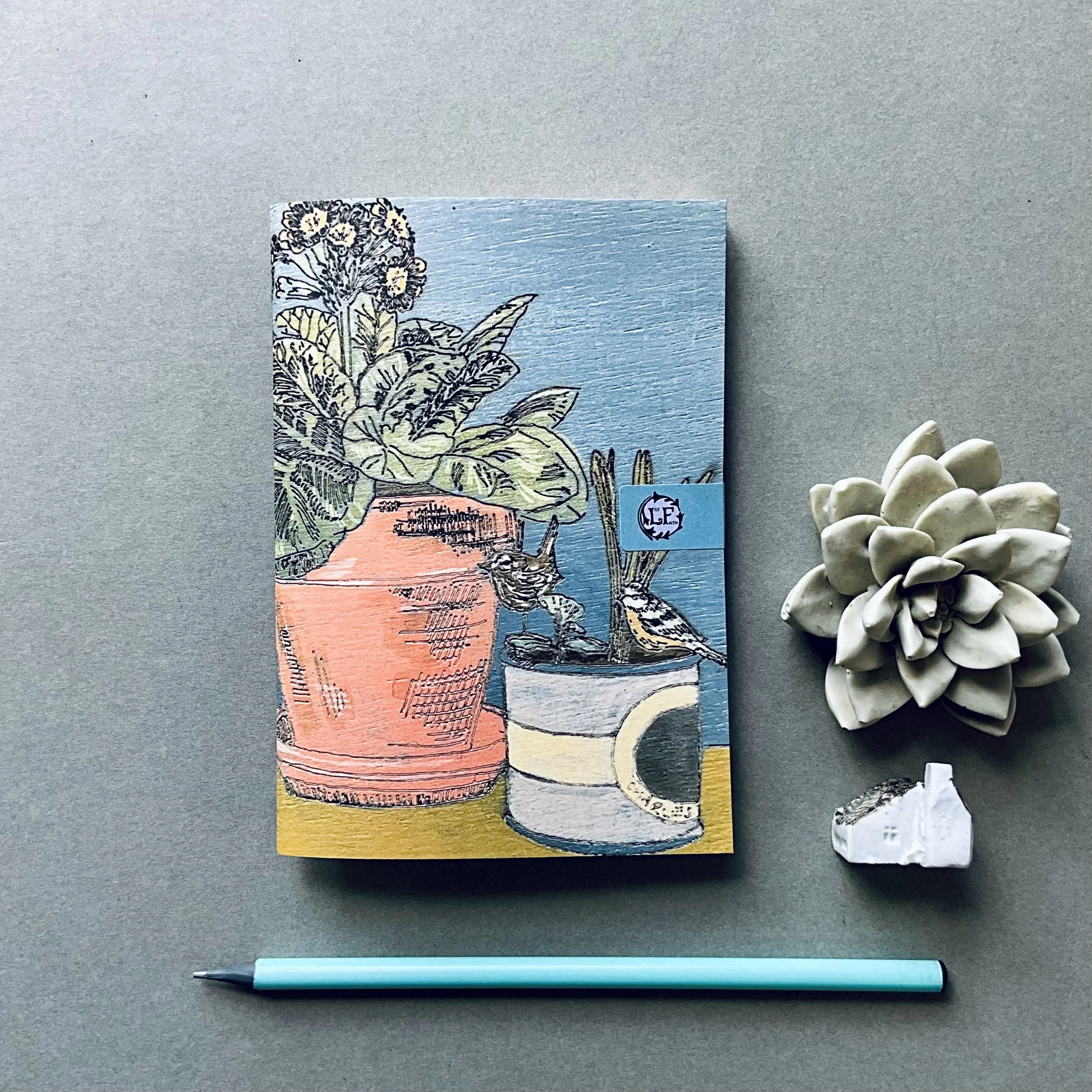 Spring Tableaux A6 Notebook, depicting Lily Faith's Spring time still life illustration featuring her favourite Auricular and plant pot companions on her dining table.