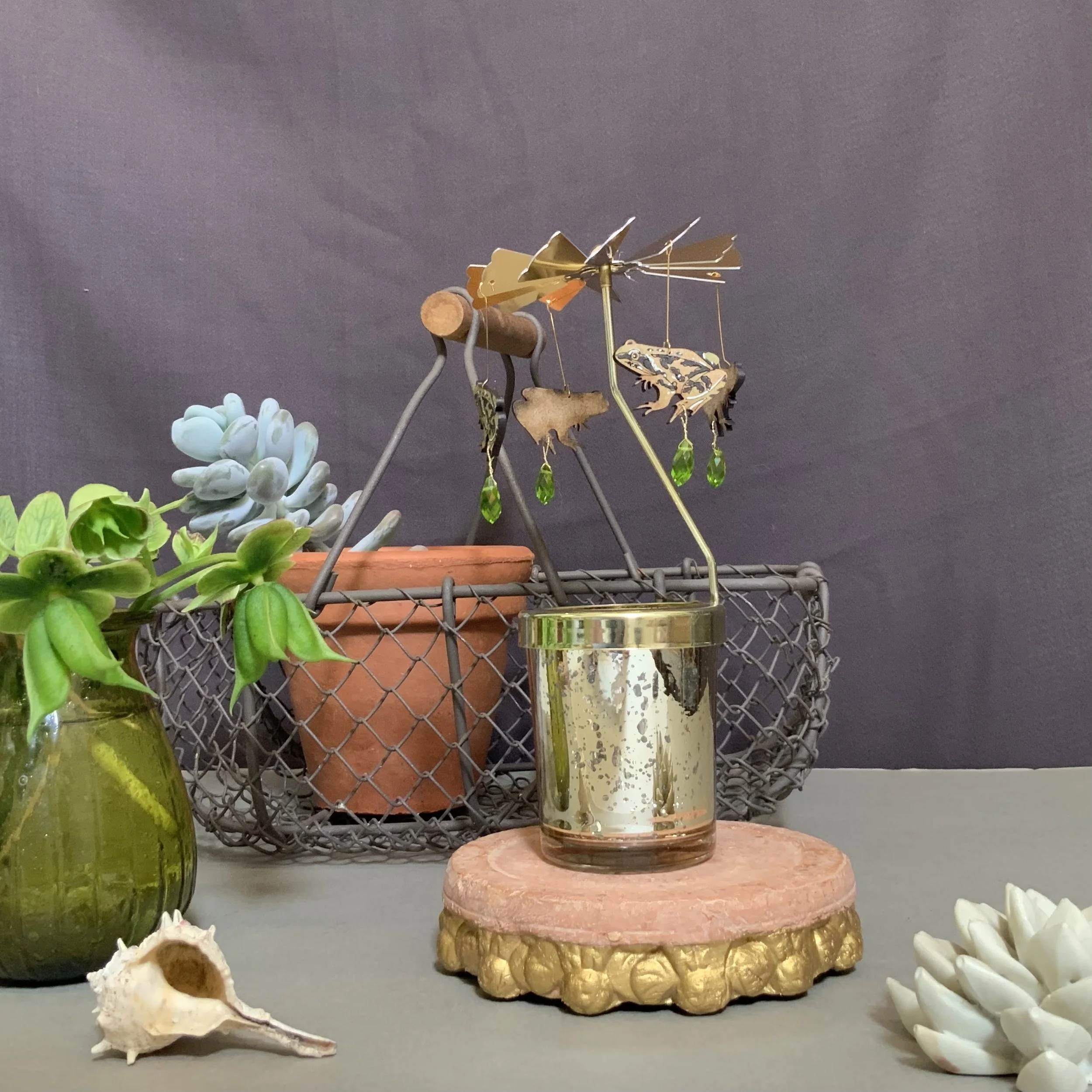 The heat from a simple tea light candle rises and hits the brass propeller, making the olive green frogs spin. Lily Faith's Frog candle carousel is child's play to set up (Copy)