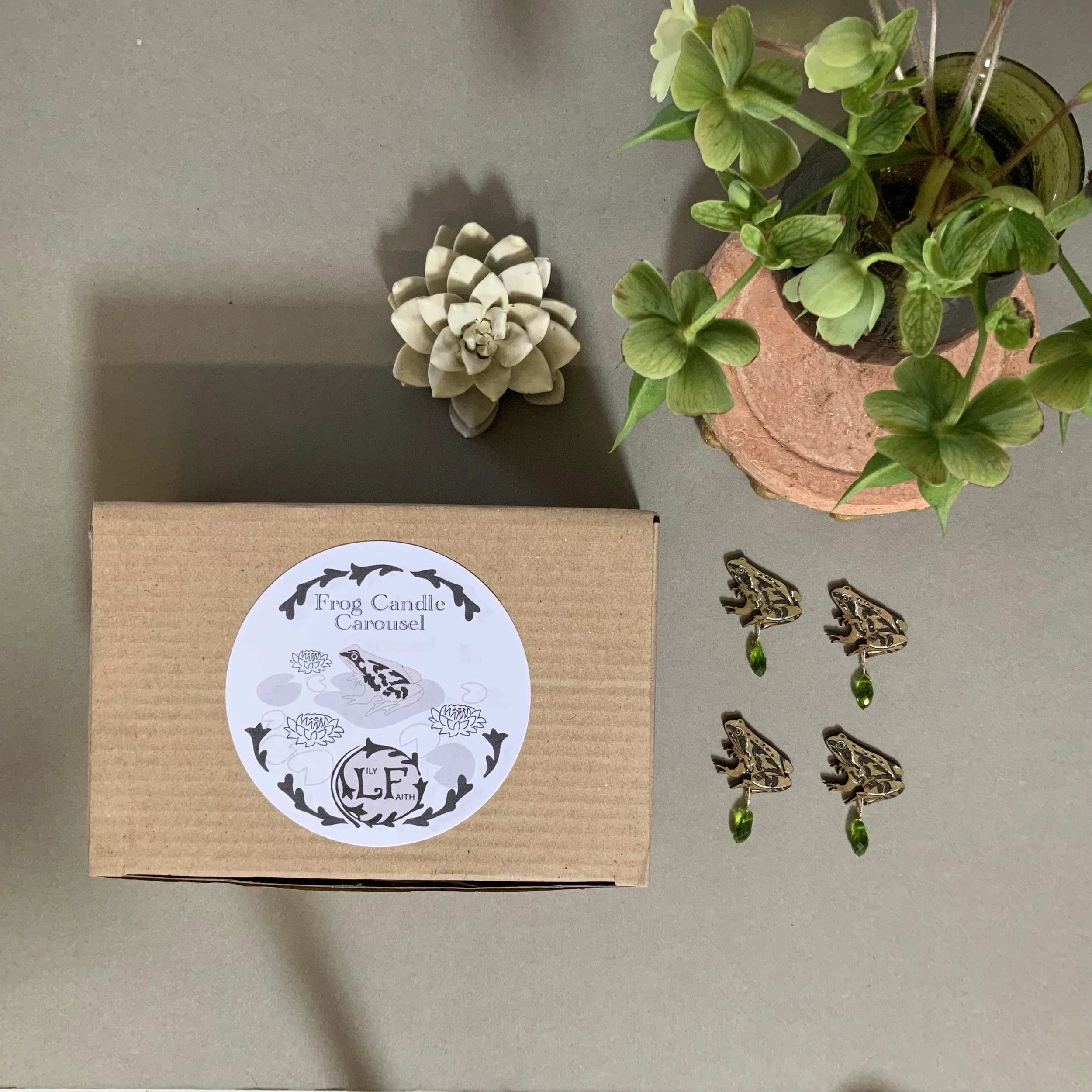 The Lily Faith Frog Candle Carousel is presented in a sturdy kraft box with a foam insert that securely holds the carousel pieces (Copy)