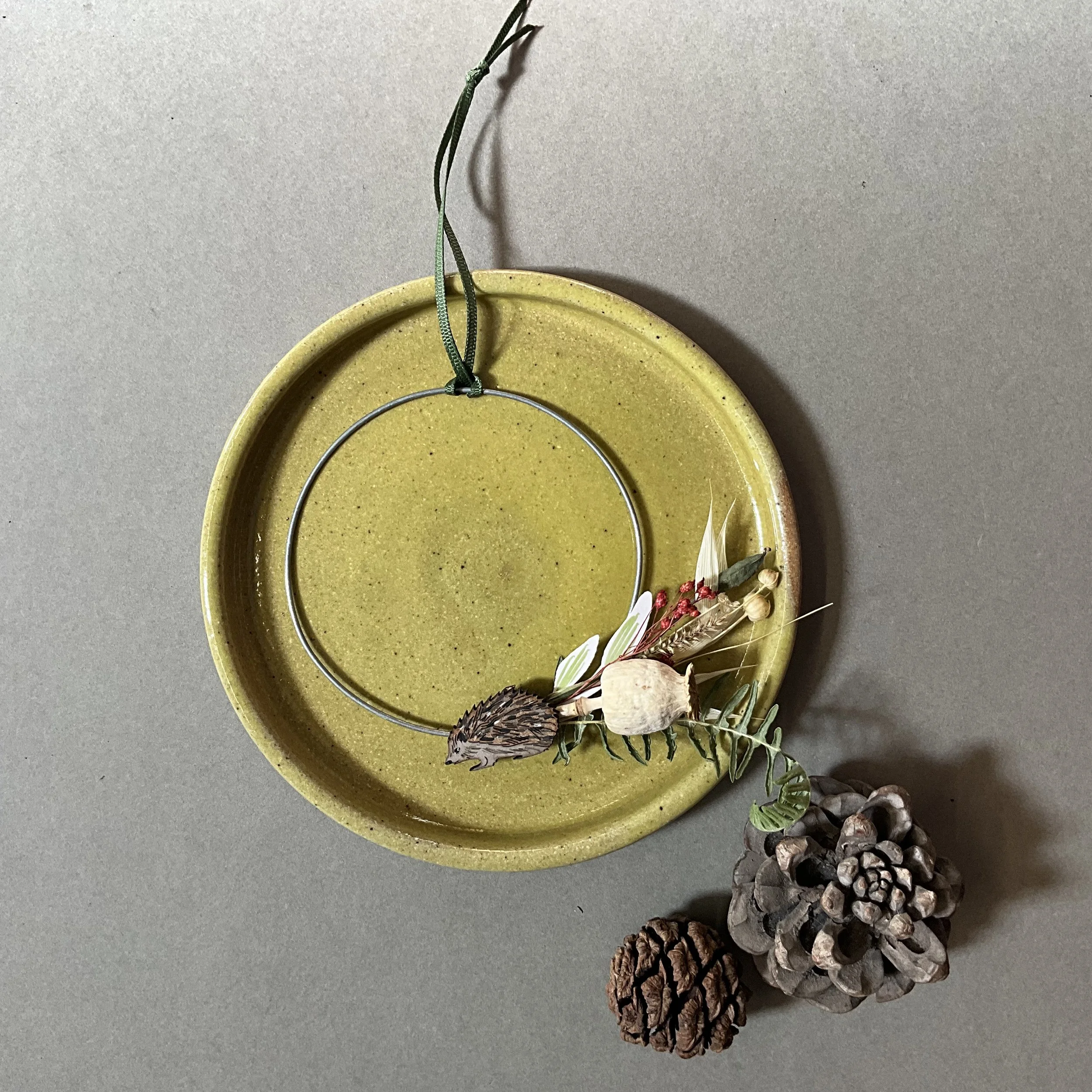 Made from hand formed wreaths shapes, locally sourced and foraged dried foliage and hand painted paper leaves, with a laser cut and etched hedgehogs. (Copy)