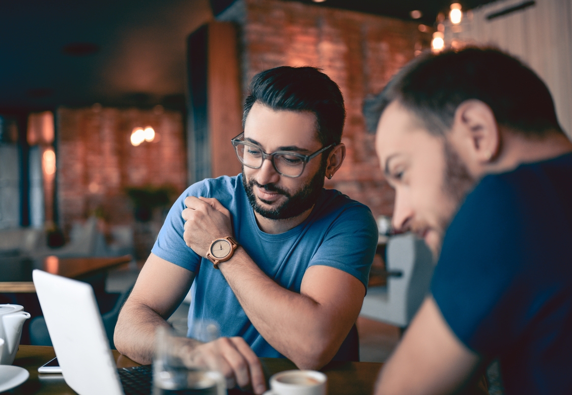 Two-Handsome-Friends-Drinking-Coffee-and-Surfing-the-Net-In-Cafe-Restaurant-855253134_1256x838.jpeg