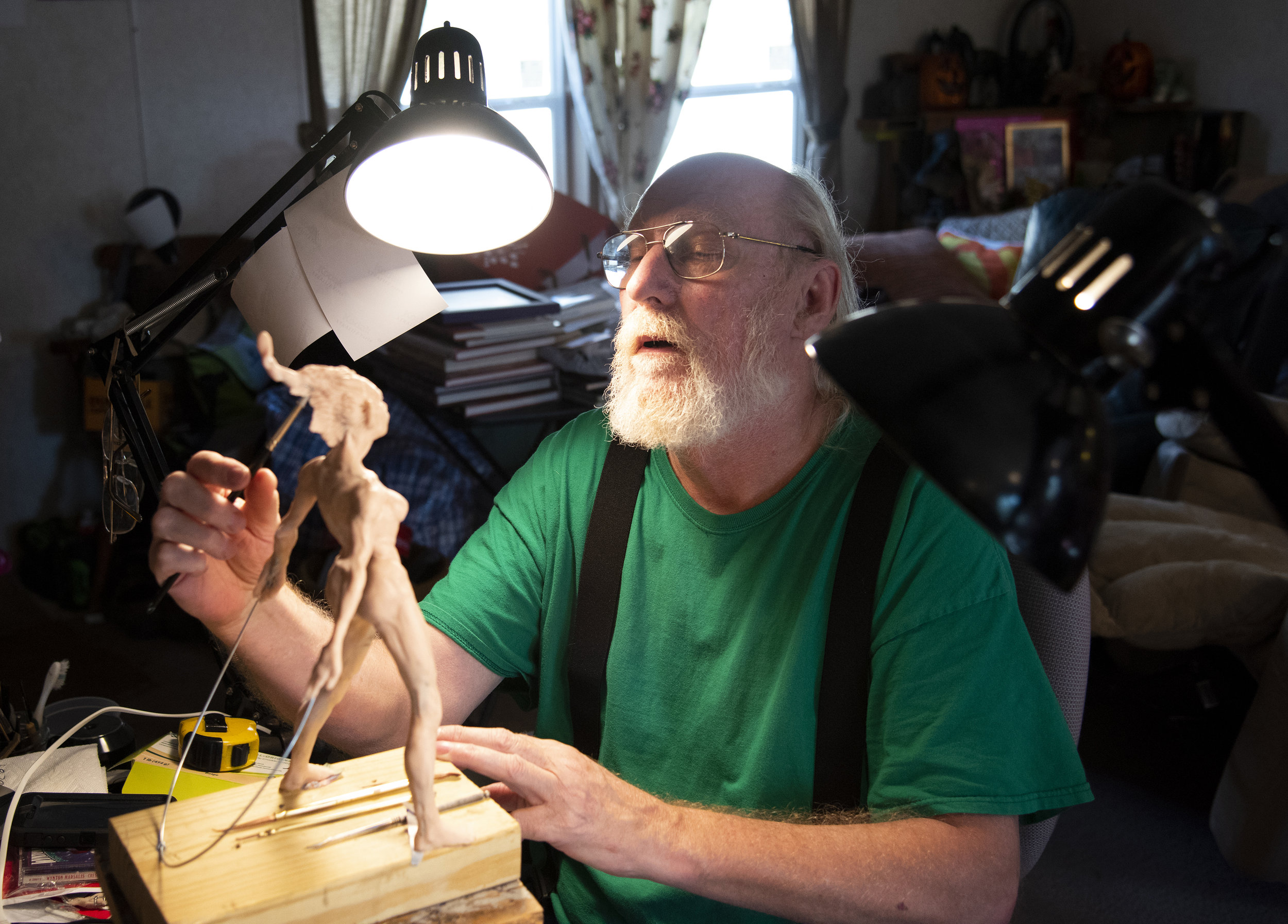 Wayne Hansen, a first generation American, works on a sculpture in his Julian Woods home. In the mid to late 1970s, Hansen helped with the construction of Julian Woods by building several homes in the community. Ironically, he says, he now lives in a factory-built home after his original house burnt down.