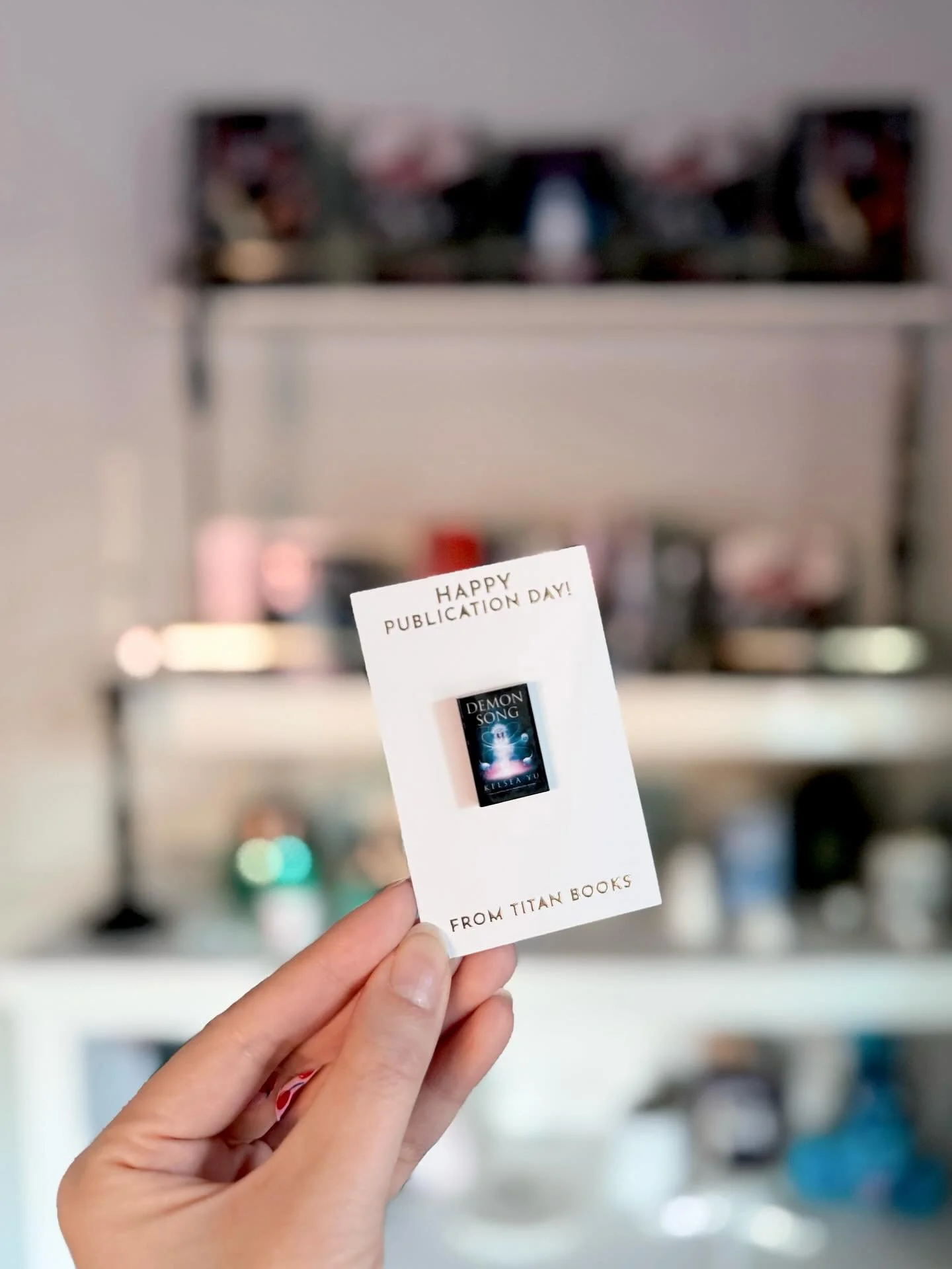 Get yourself a publisher who sends you a miniature book pin to celebrate release day&hellip;and a friend who makes you a book keychain and brings it to your launch!! Thank you @titanbooks &amp; @slangwrites!!!!! 🥰🫶🖤

#demonsong #kelseayu #bookishl