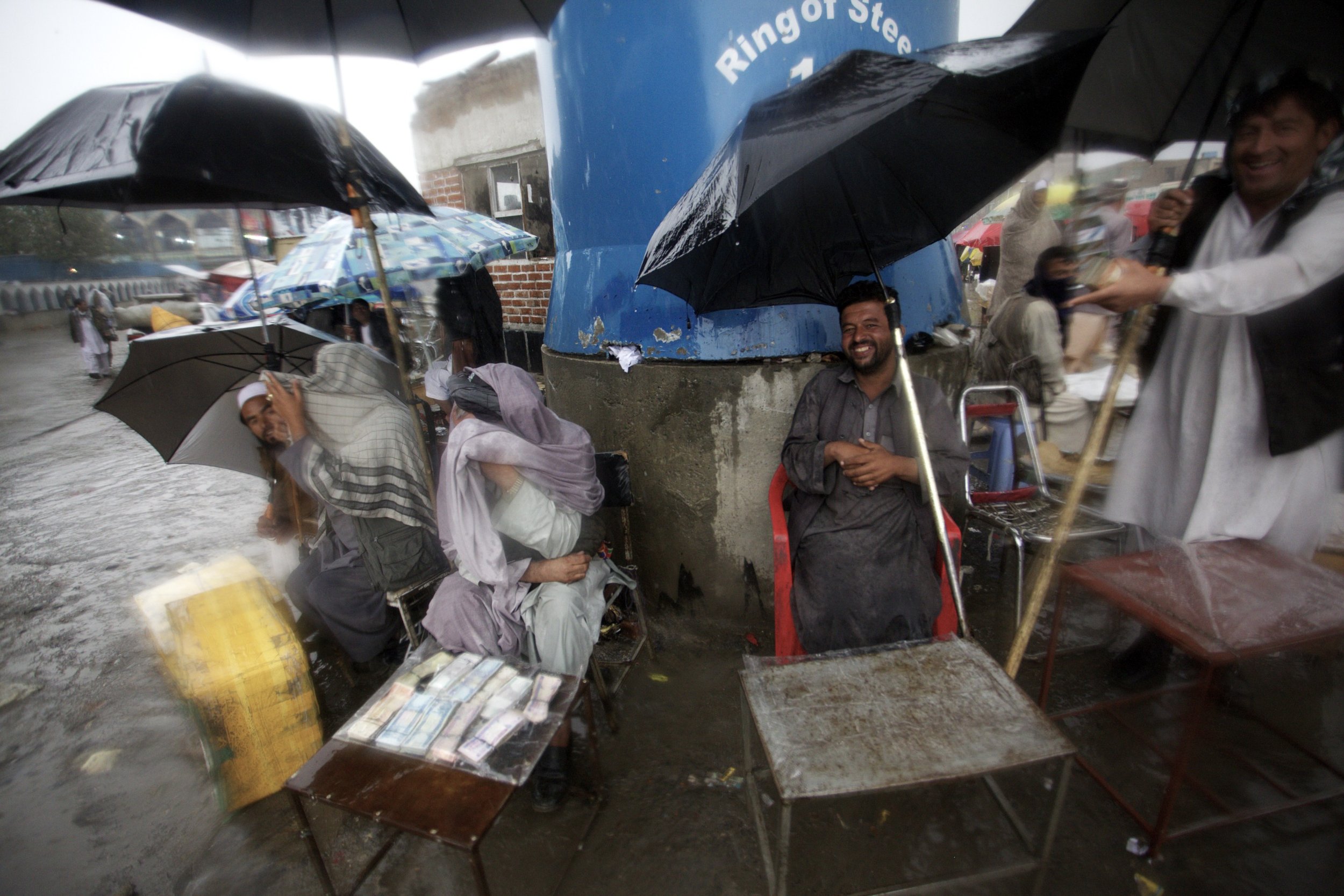  Police and bystanders at a take shelter at a checkpoint in Kabul amidst a rainstorm, 2011. 