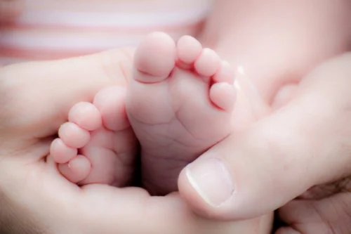 Baby's feet held in adult's hands 