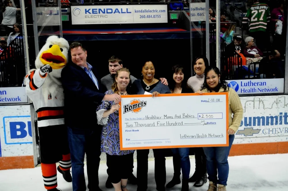 Members of the Komets organization present large check to Healthier Moms and Babies during a period break of a hockey game. 