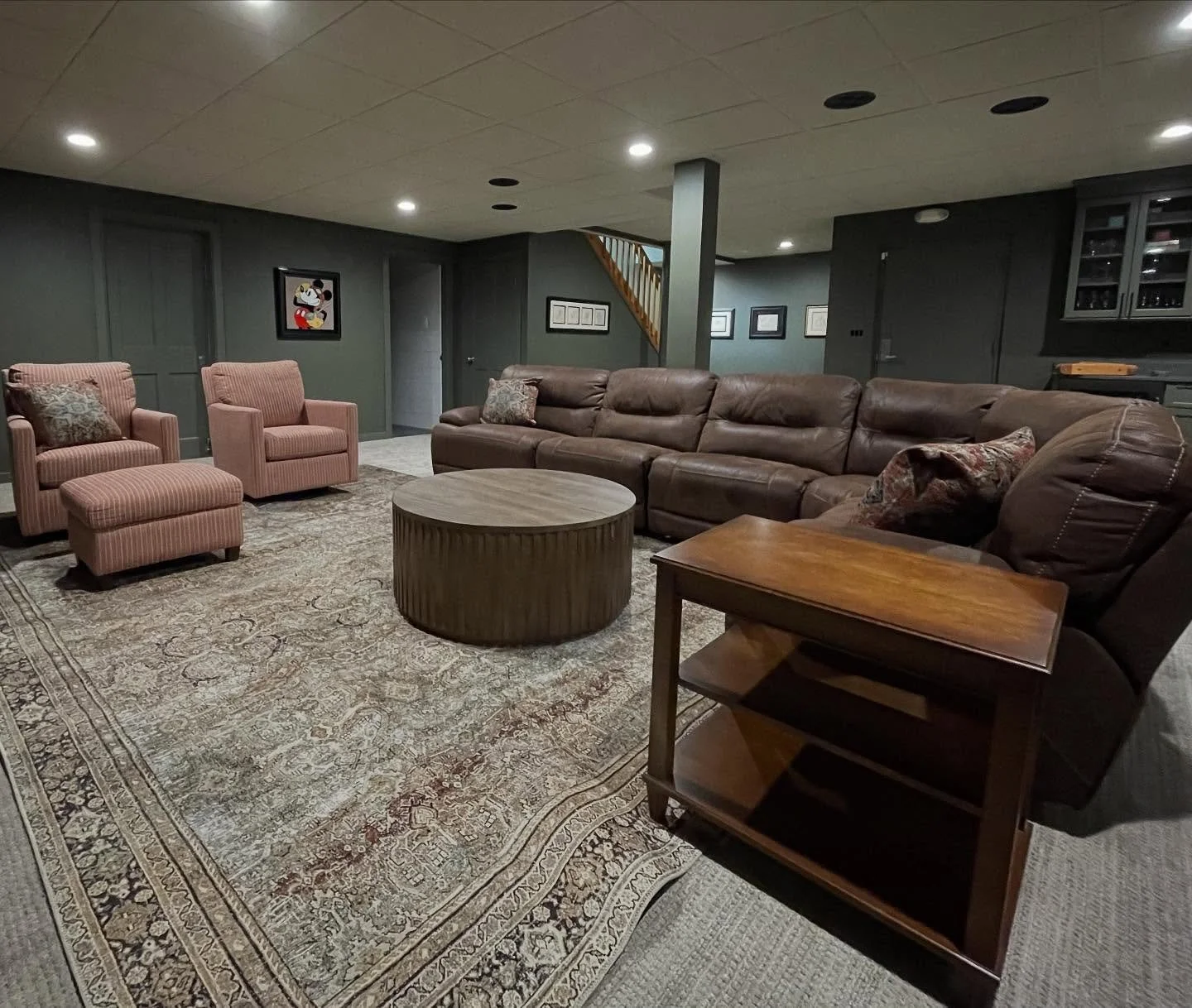 Basements can be dark, why not embrace it! We color drenched this (almost) windowless space with a warm green and created a movie theater like atmosphere with a bar.  Swipe for before.