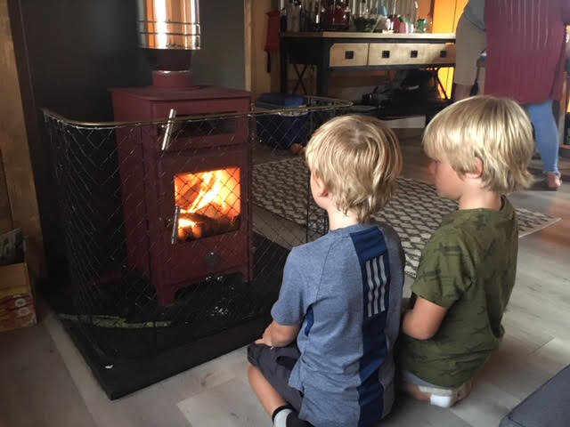 Boys by woodburning stove