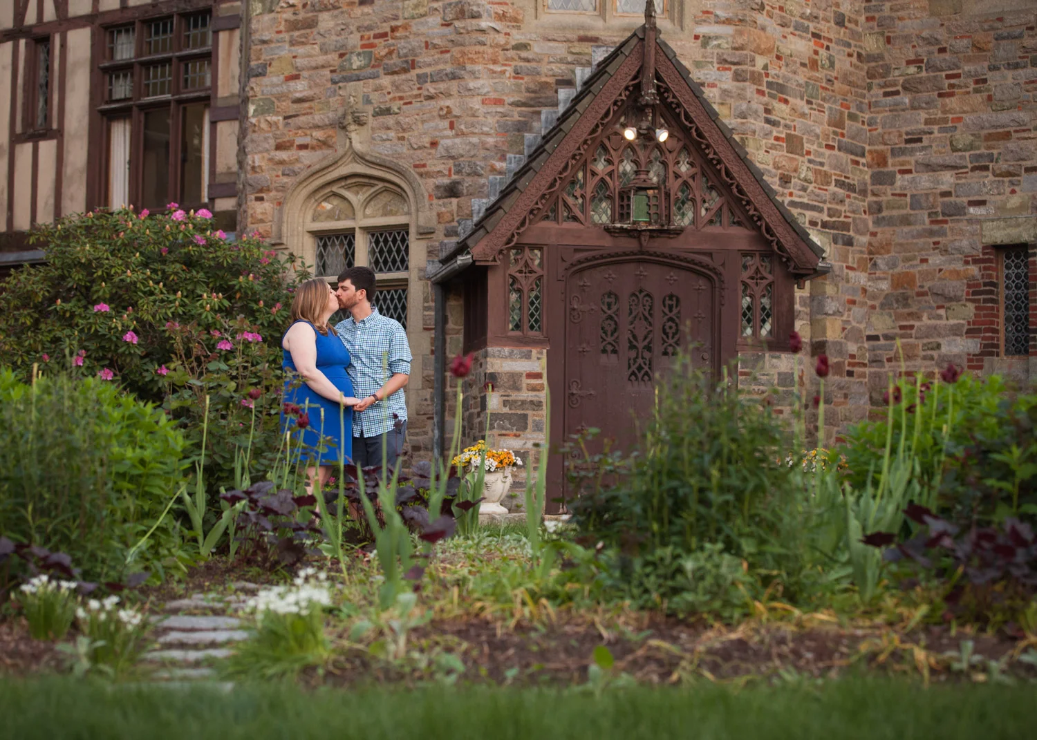 Man and woman kiss in the garden front of WPI's Higgins House.
