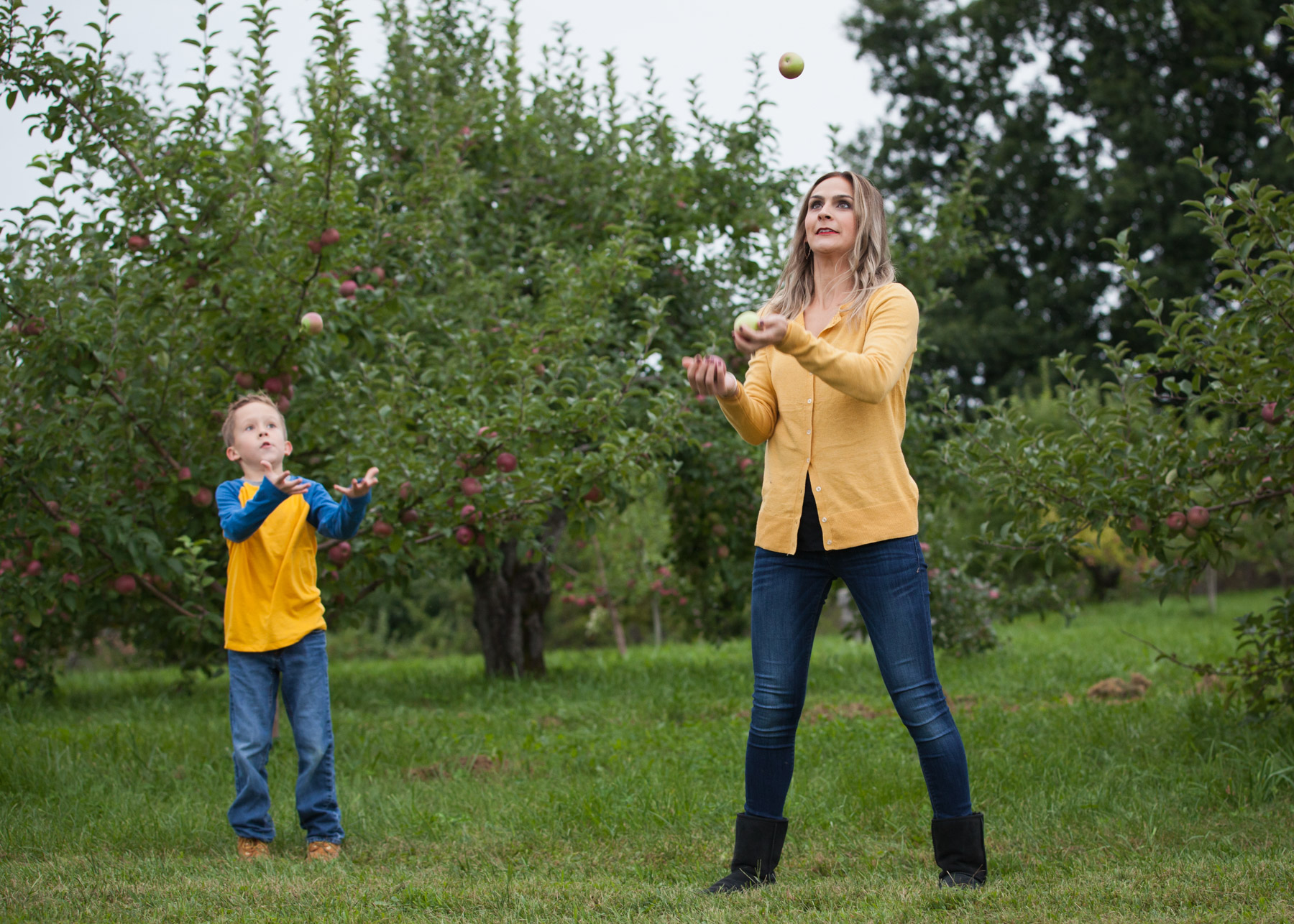 Mother and son juggle apples in an apple orchard in Easthampton, MA.