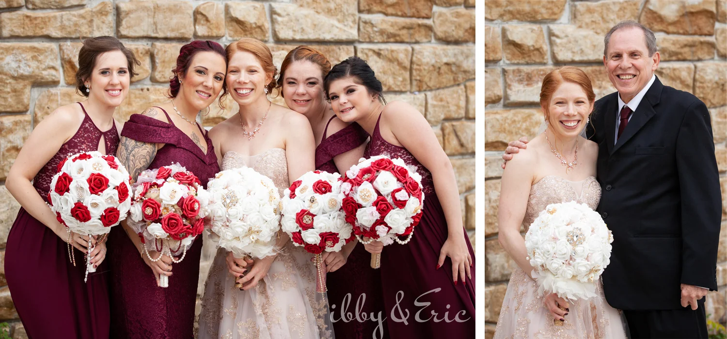 Bride with red hair poses for photos with her dad and her bridesmaids holding red and white bouquets and wearing burgundy dresses.