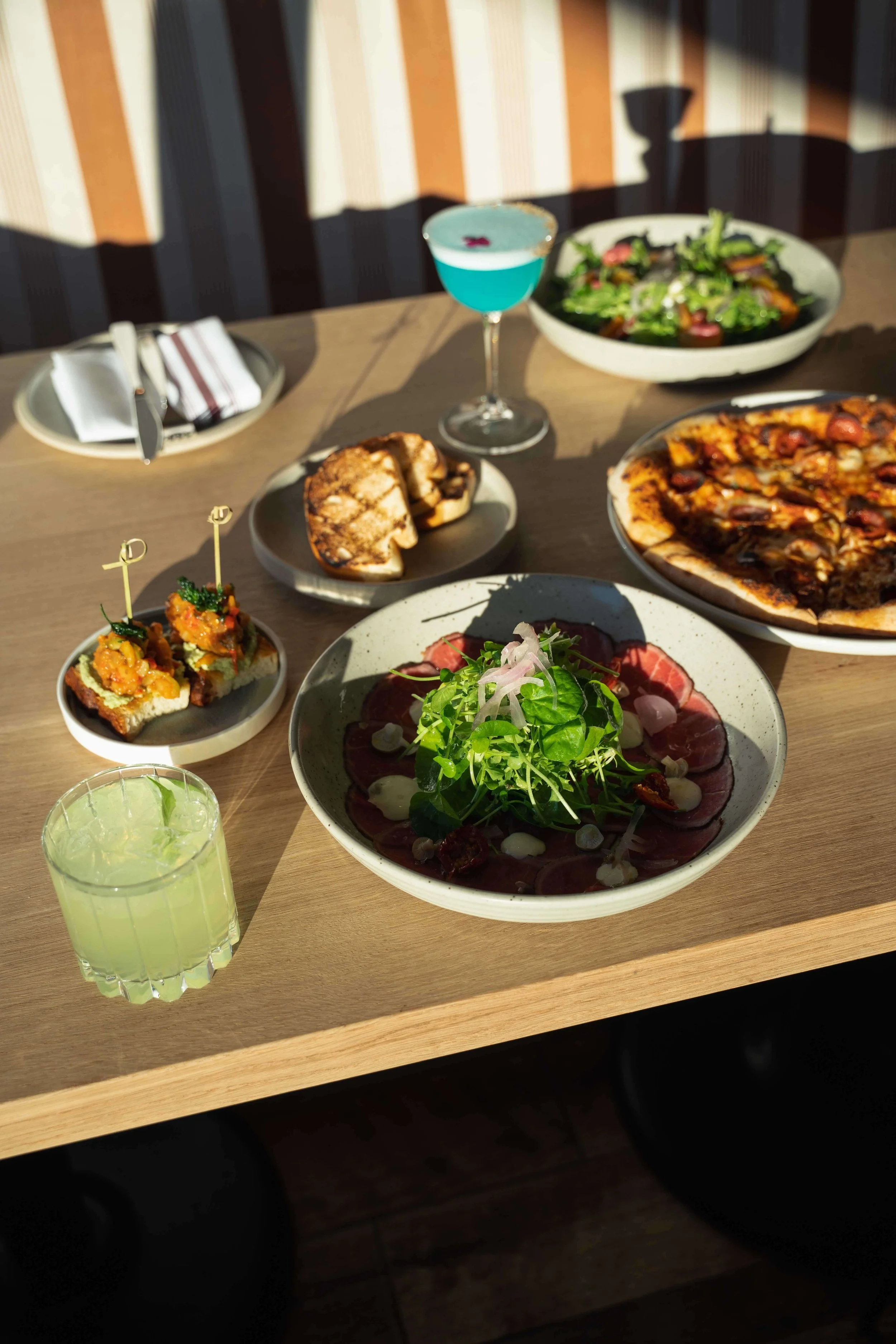 Fresh salad served alongside slices of pizza on a dining table.