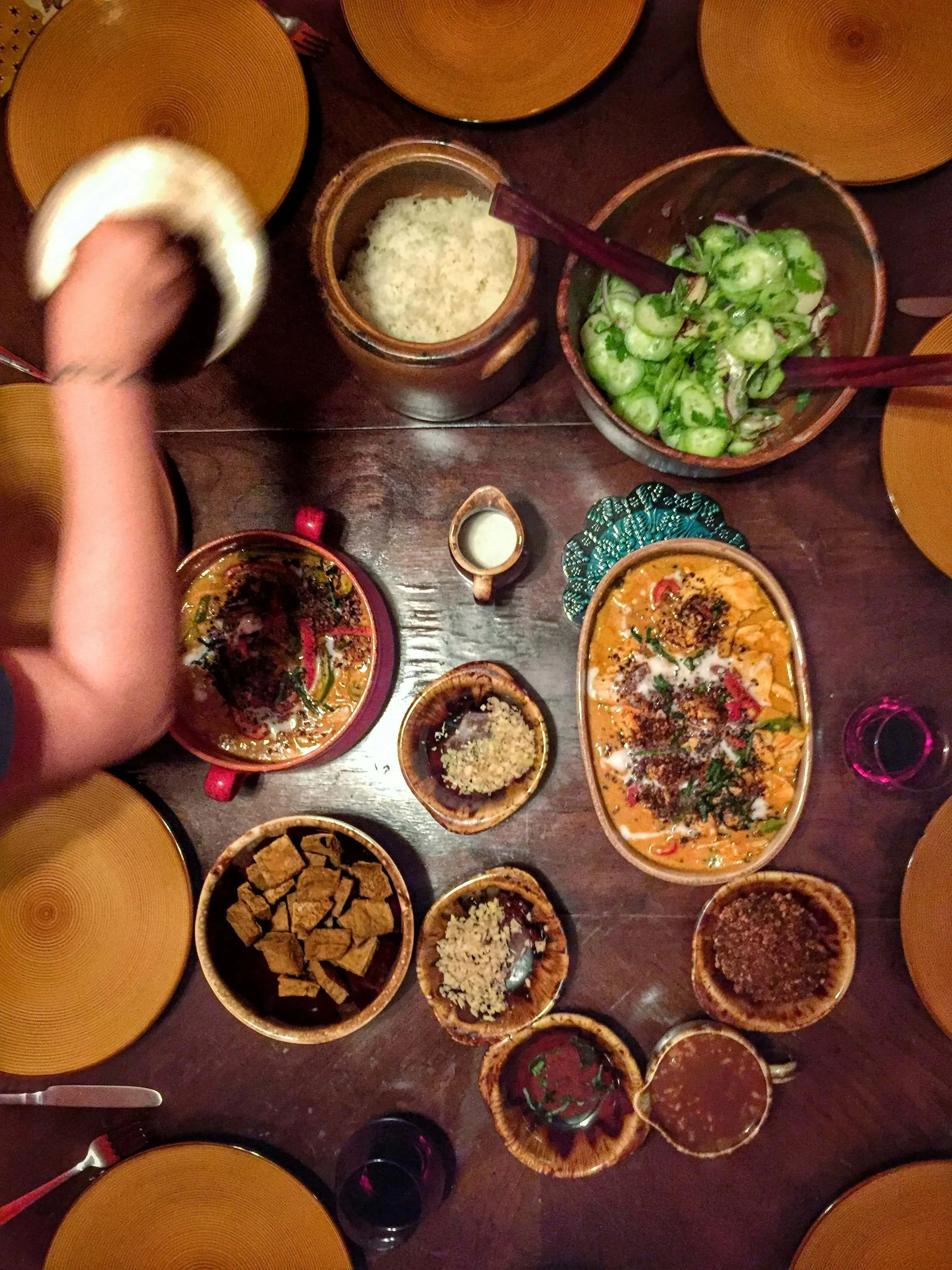 Overhead view of a shared meal with several dishes arranged around a dining table