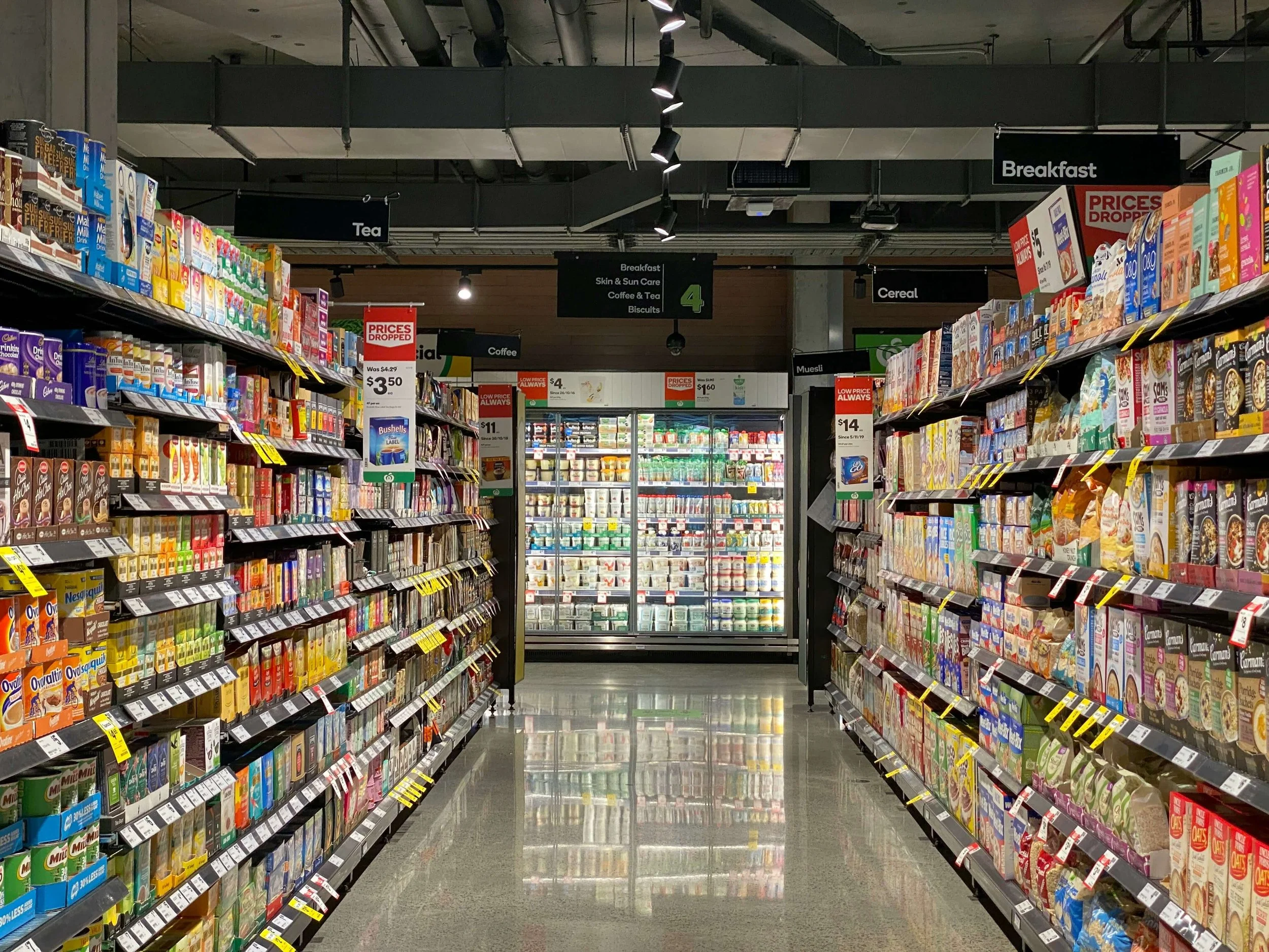 Grocery store aisle with shelves of packaged foods on both sides.