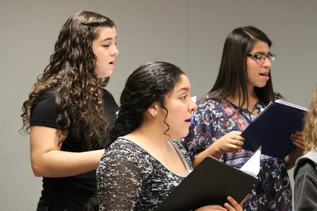 High school female students rehearsing for a vocal jazz performance