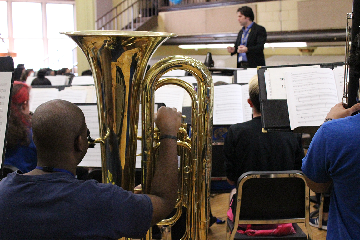 African-American student tuba player watches director during rehearsal at Joliet Central High School.