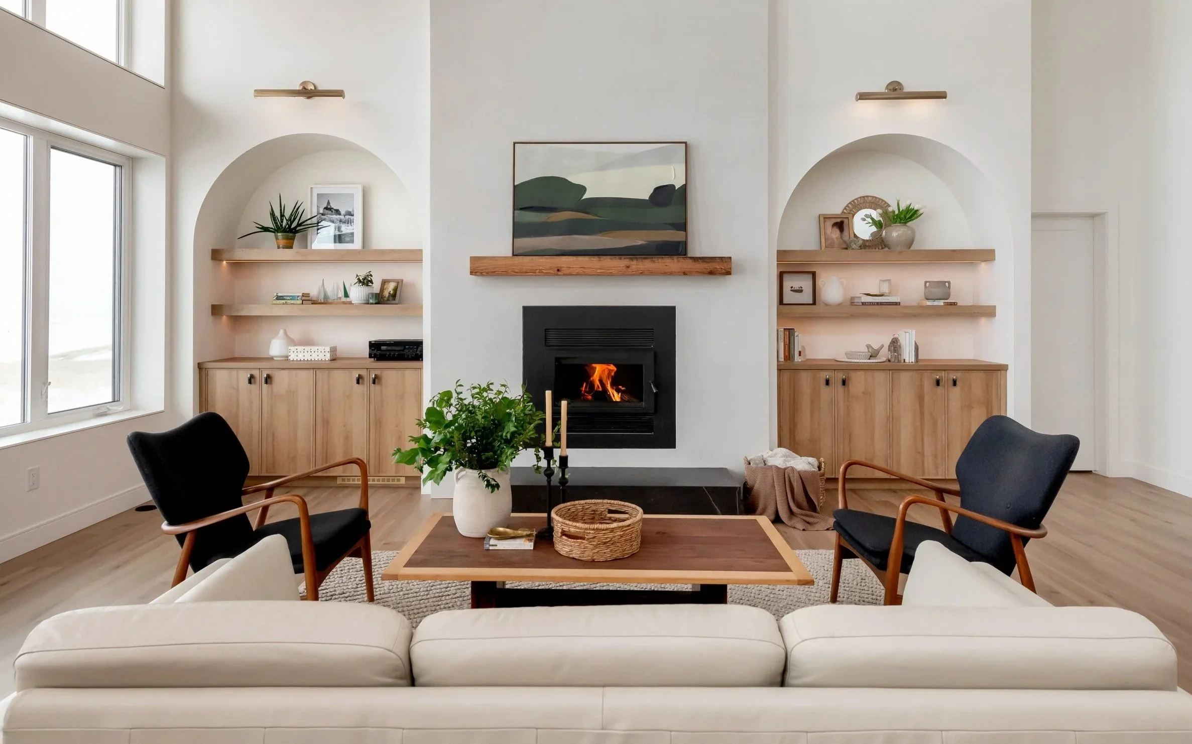 Acreage great room near Saskatoon designed by Metric Design, with white oak built-ins and arched niches flanking the fireplace
