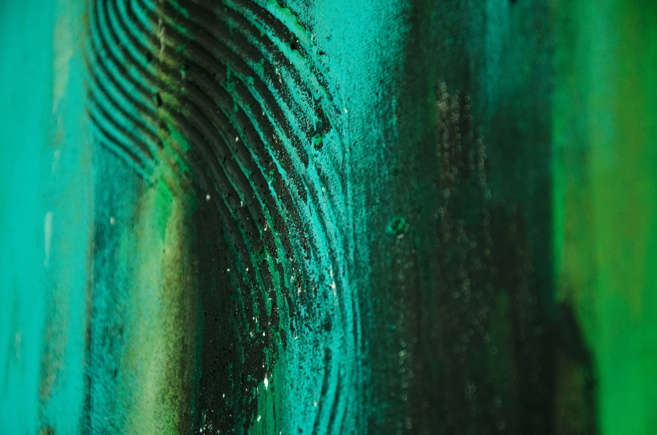 Nahaufnahme eines bunten, schimmernden, grünen und blauen Elements mit Textur und Linien.
