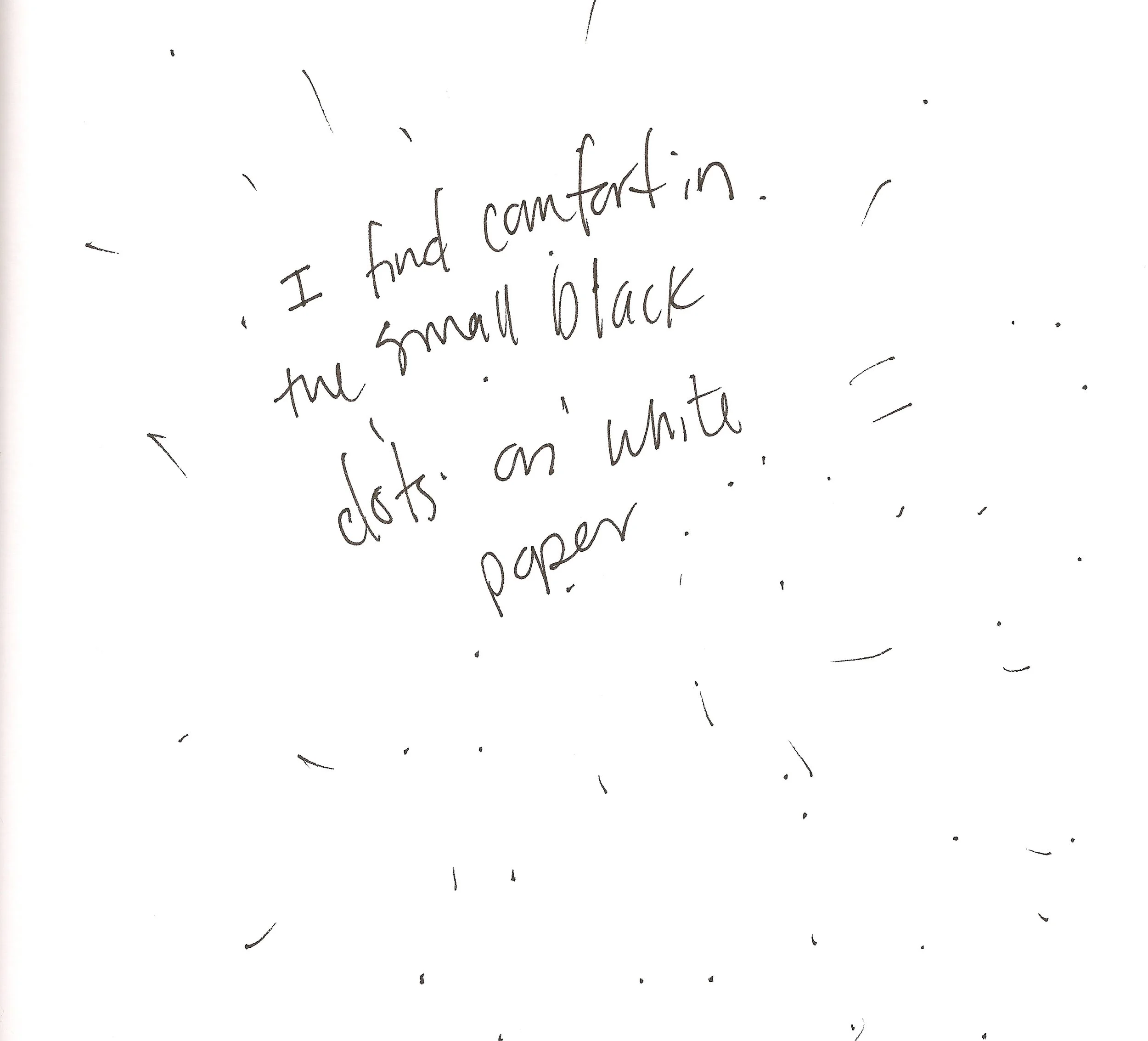A handwritten note on white paper. The note reads: 'I had comfort in the small black dots on white paper'.