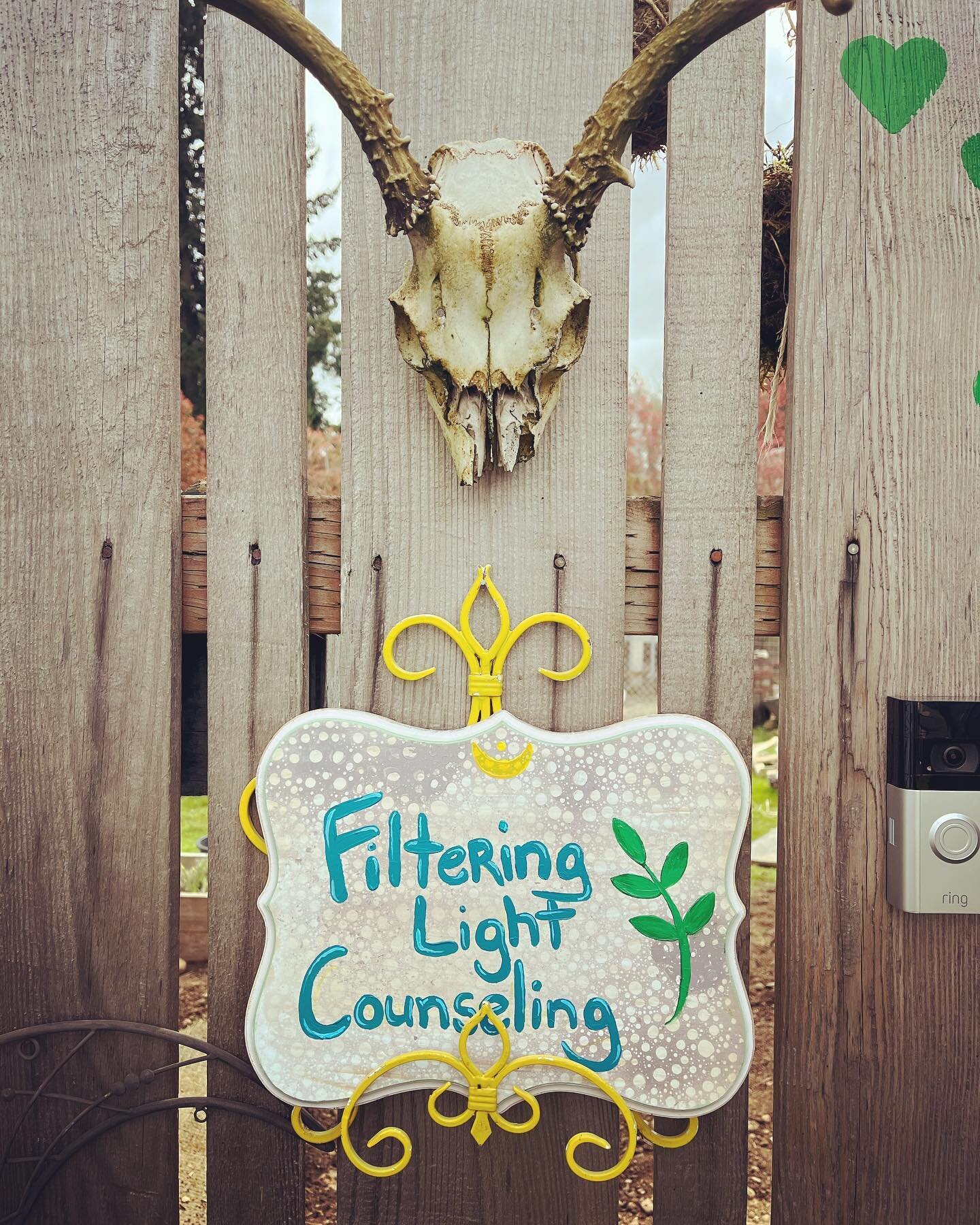 Ding dong! Tomorrow is the opening day for the ecotherapy backyard office and #filteringlightcounseling! [ID a fence holds a deer skull and below it is a sign that Kim painted that says Filtering Light Counseling with a RING doorbell to the right]