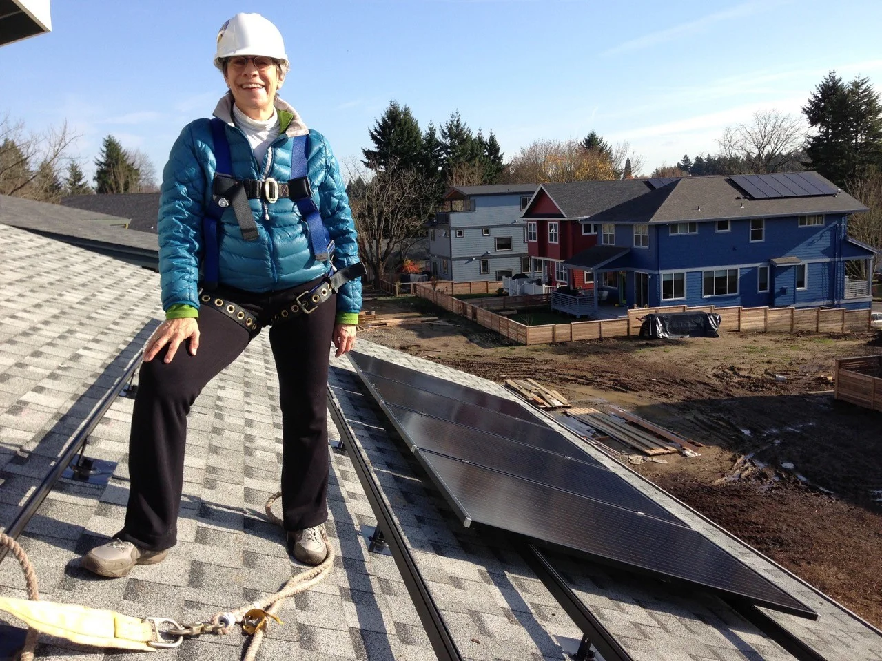 Margie Harris standing on her rooftop with her solar modules.