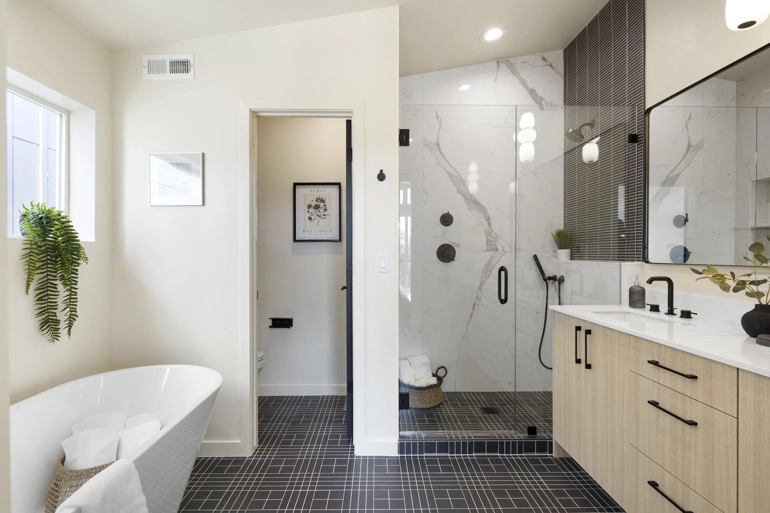 Stuart Residences primary bathroom with freestanding tub and marble tile shower