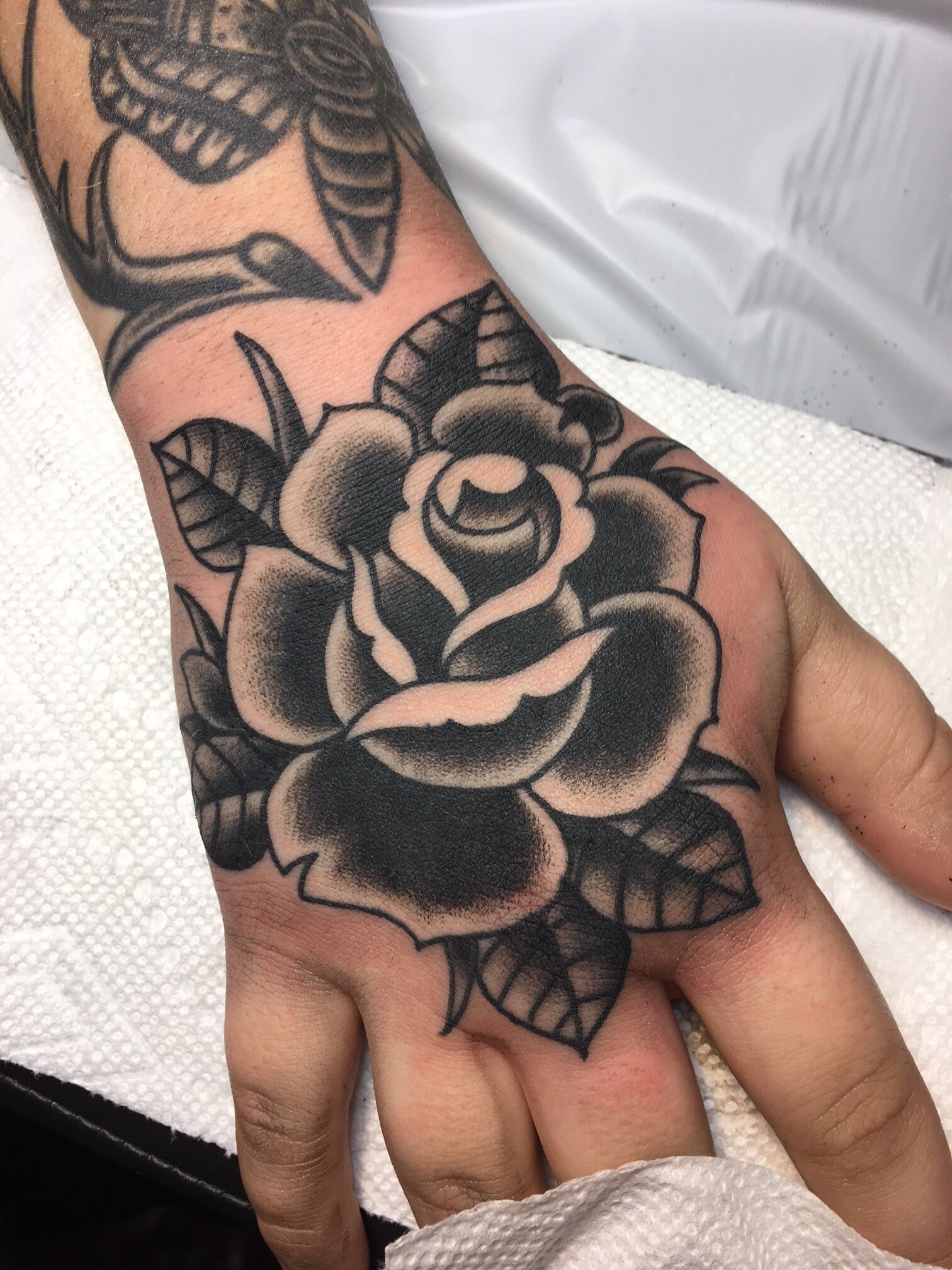 Bold black rose tattoo on hand by Brian Gattis at Southern Star Tattoo in Atlanta, Georgia