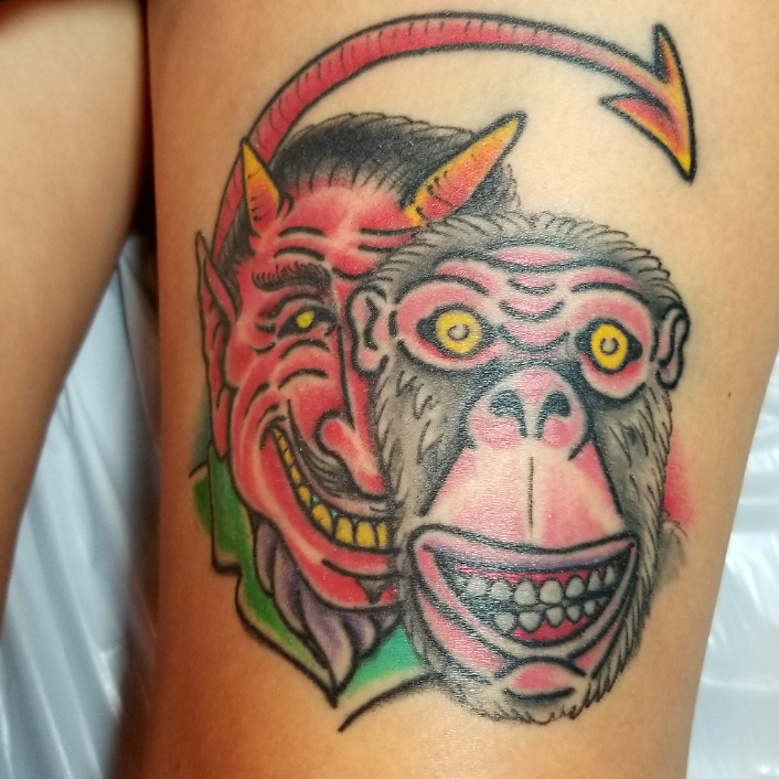 New School monkey tattoo on the upper arm.