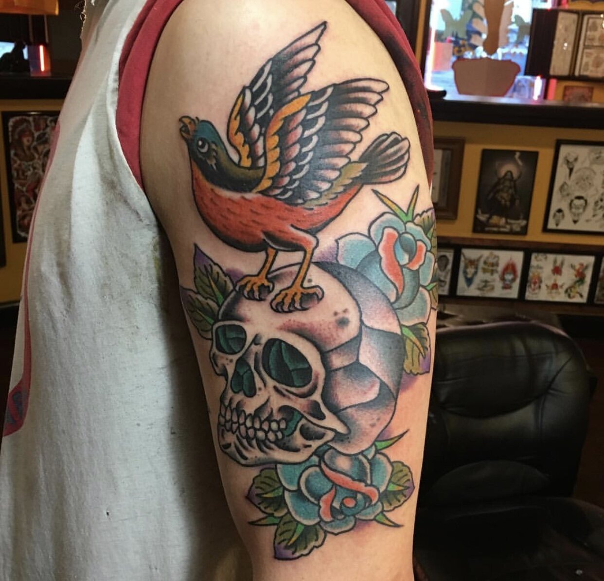 Skull, bird and roses tattoo in traditional color by Andrew Patch at Southern Star Tattoo in Atlanta, Georgia.