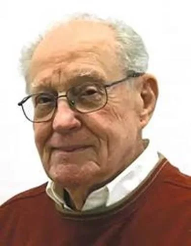 An older man in glasses and a red sweater