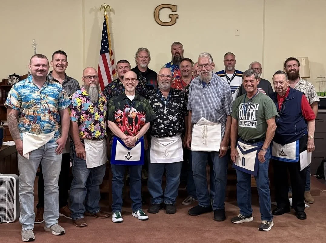 A group of 15 men and Freemasons of diverse ages standing with Masonic aprons on