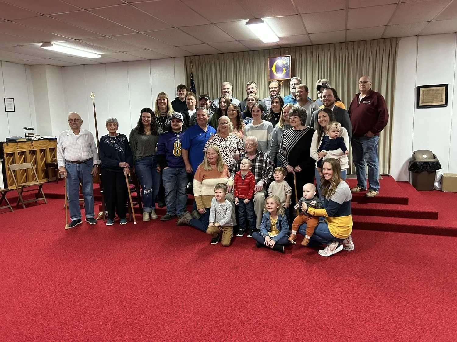 A group of men, women, and children posing for a picture in a Masonic lodge