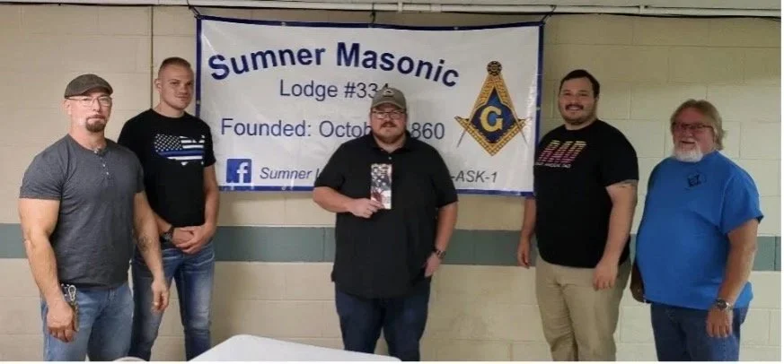 Members of Sumner Lodge pose in front of Lodge banner
