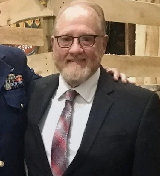 WB Eric Wilson, an Illinois Freemason, in a suit and tie and glasses, smiling at the camera