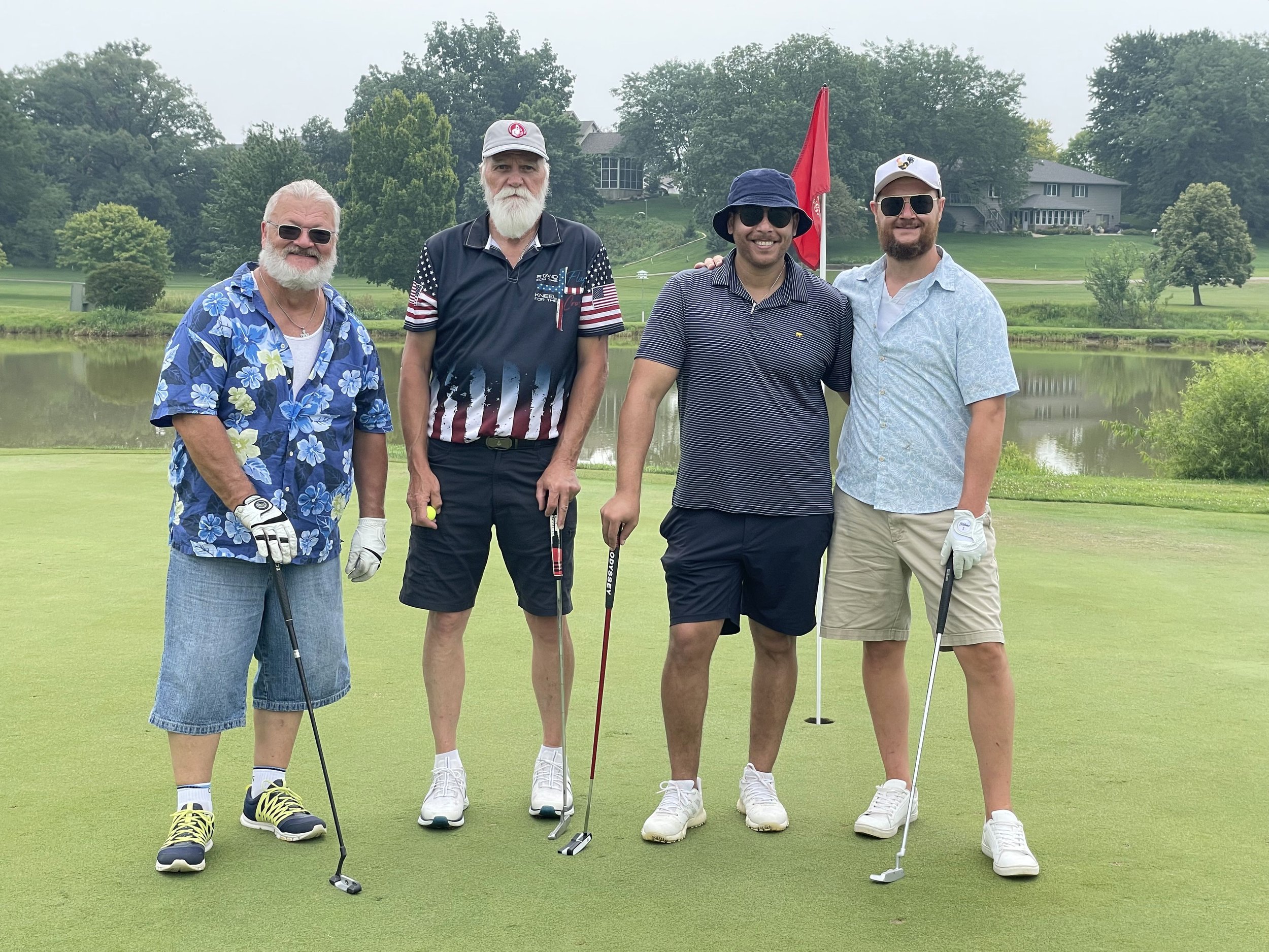 Four men and Freemasons of diverse ages playing golf together