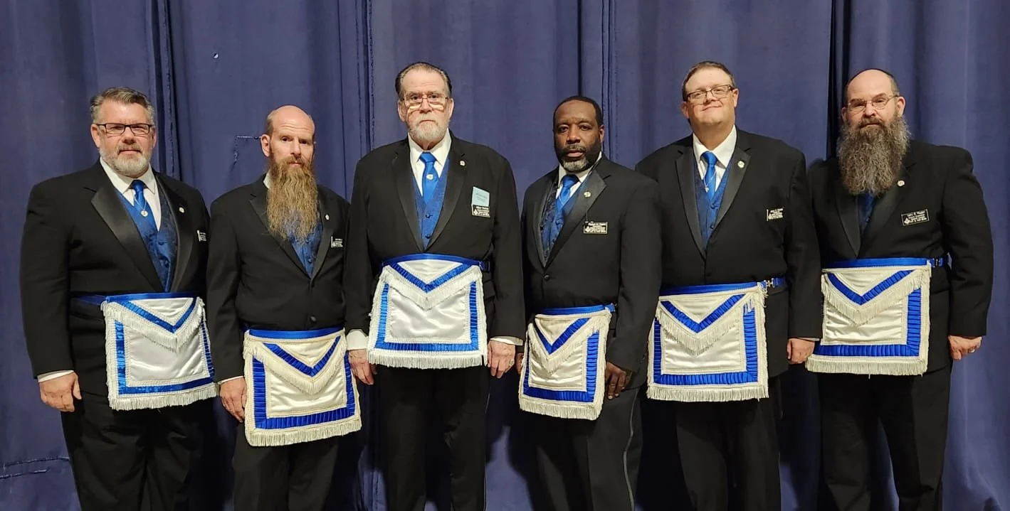 Six men and Freemasons standing alongside each other in Masonic aprons representing the Grand Lodge of Illinois A.F. & A.M.’s Board of Grand Examiners