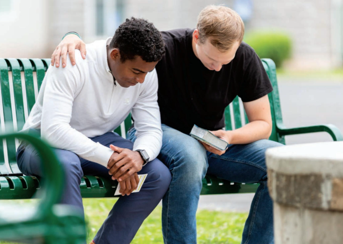 Two men sitting on a park bench deep in thought
