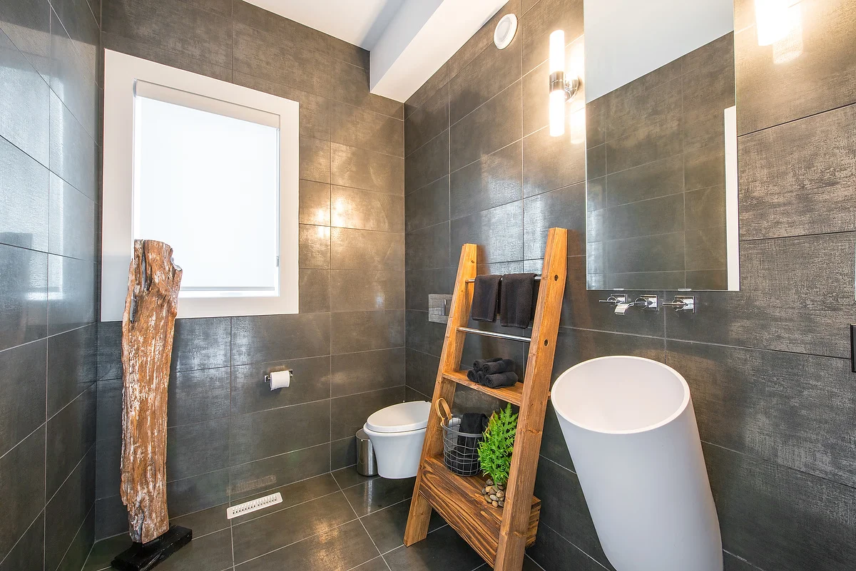 This cool, crisp bathroom features a minimal style, with contrasting rustic elements that bring personality and warmth to the space. Jehan custom ordered a locally made shelf specifically for this room.