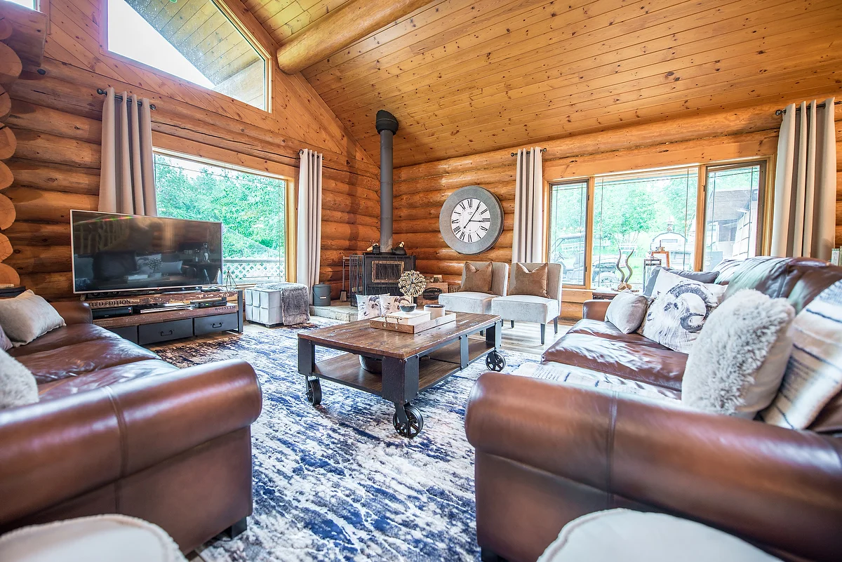 Although this space is dominated by a rustic aesthetic, elements like the blue carpet, ripple fold drapes and grey contemporary chairs add a touch of modern design.