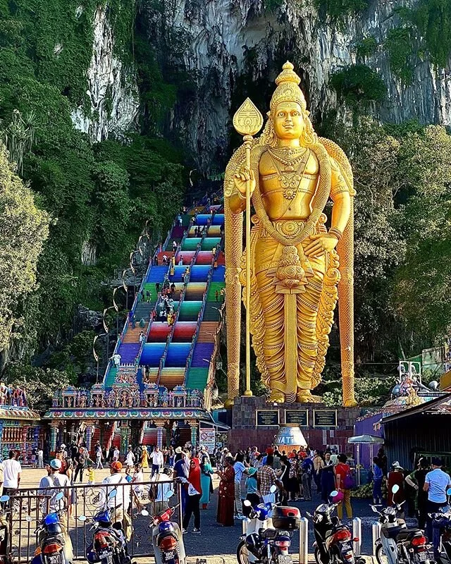 #batucaves #malaysia 
A colossal gold-painted statue of Murugan, made from reinforced concrete and 140 feet (42.7 metres) in height, stands near the base of a flight of 272 steps. As visitors climb the steps, they are frequently accosted by macaques 