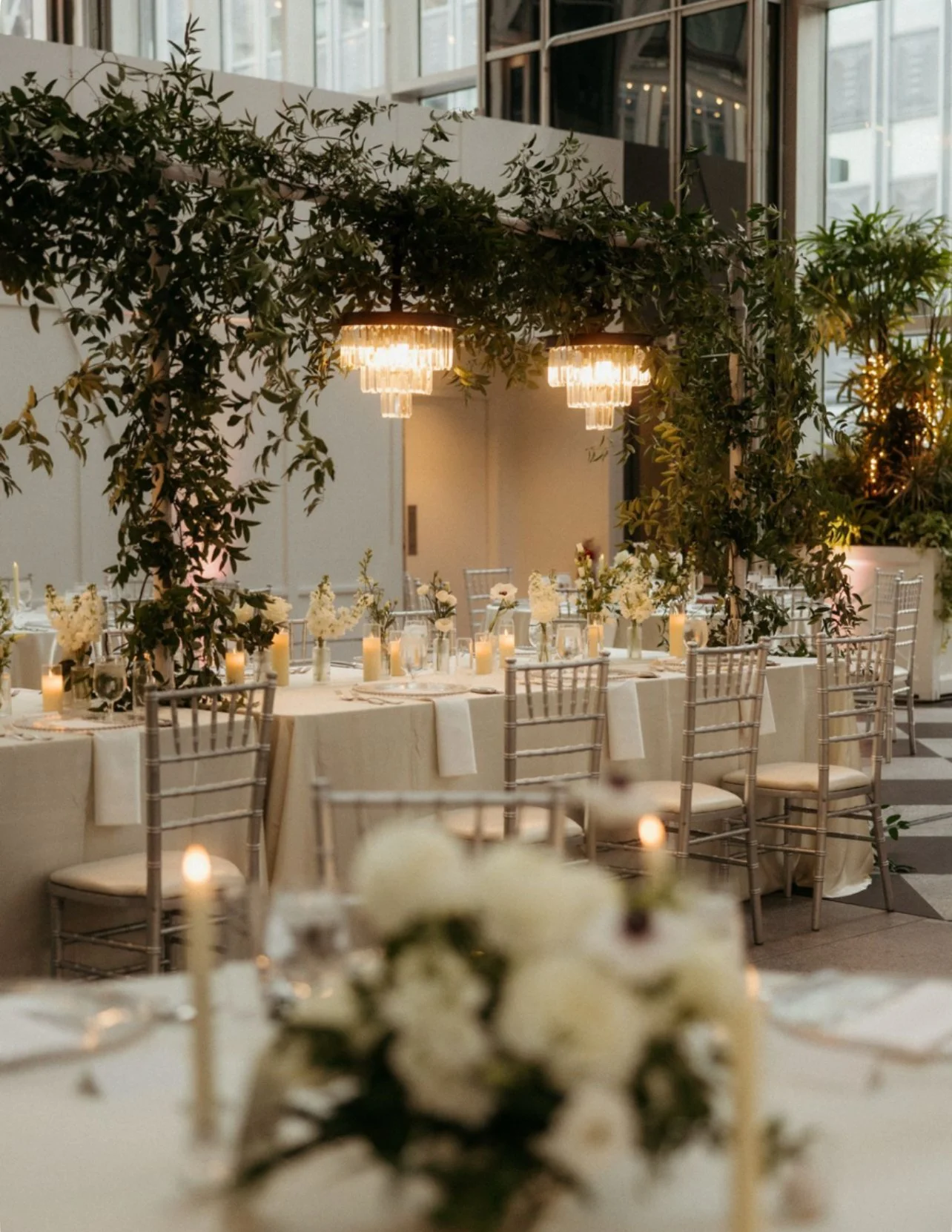 Lkush greenery installation on guest tables at a wedding reception in the Wintergarden in Pittsburgh, designed by a Pittsburgh wedding florist.