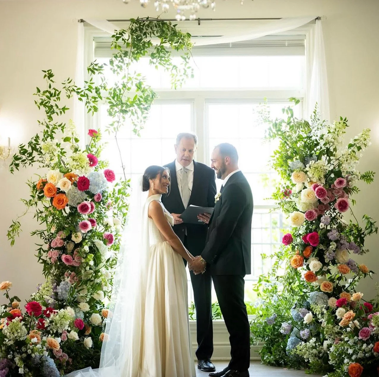 Bride and Groom at Twelve Oaks Mansion with a lush romantic garden inspired ceremony floral installation designed by a Pittsburgh wedding florist.