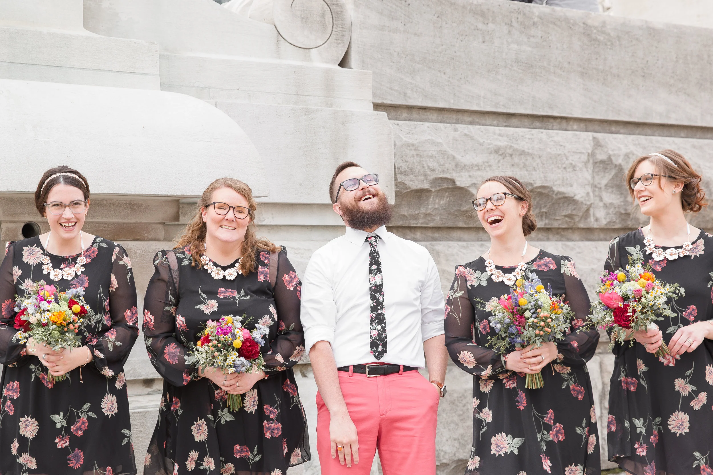 groom laughing with bridesmaids in downtown indianapolis