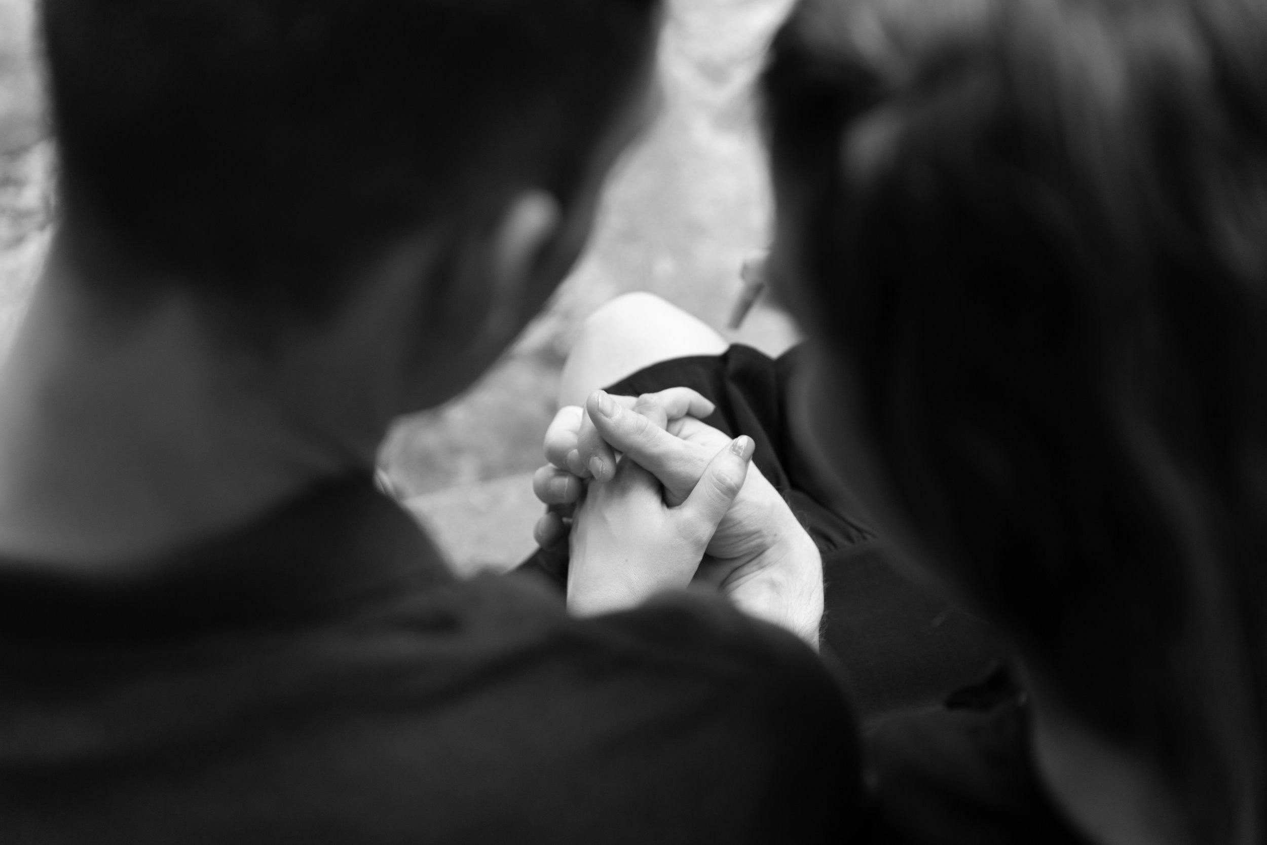 black and white image of engaged couple holding hands