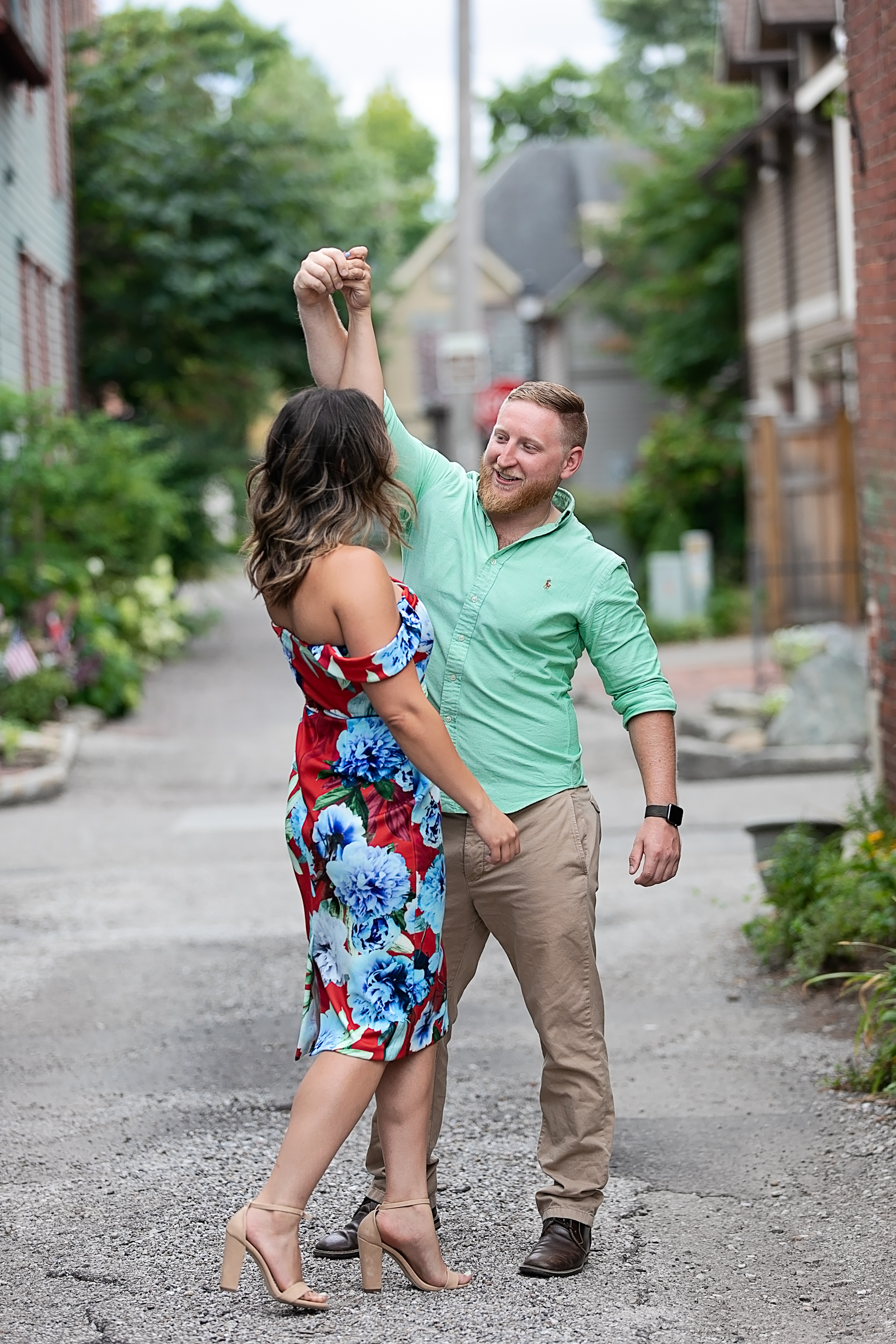 engaged couple dancing on a city street