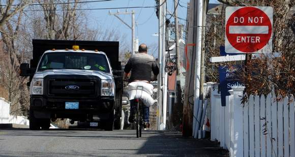  Carrying sandbags on a bike in preparation for a coming nor'easter (Photo: Steve Heaslip/Cape Cod Times) 