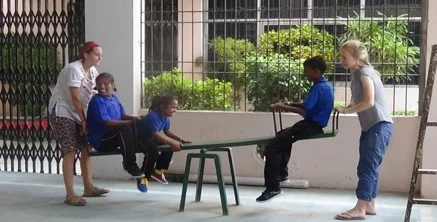Volunteers with chidren on see saw.jpg