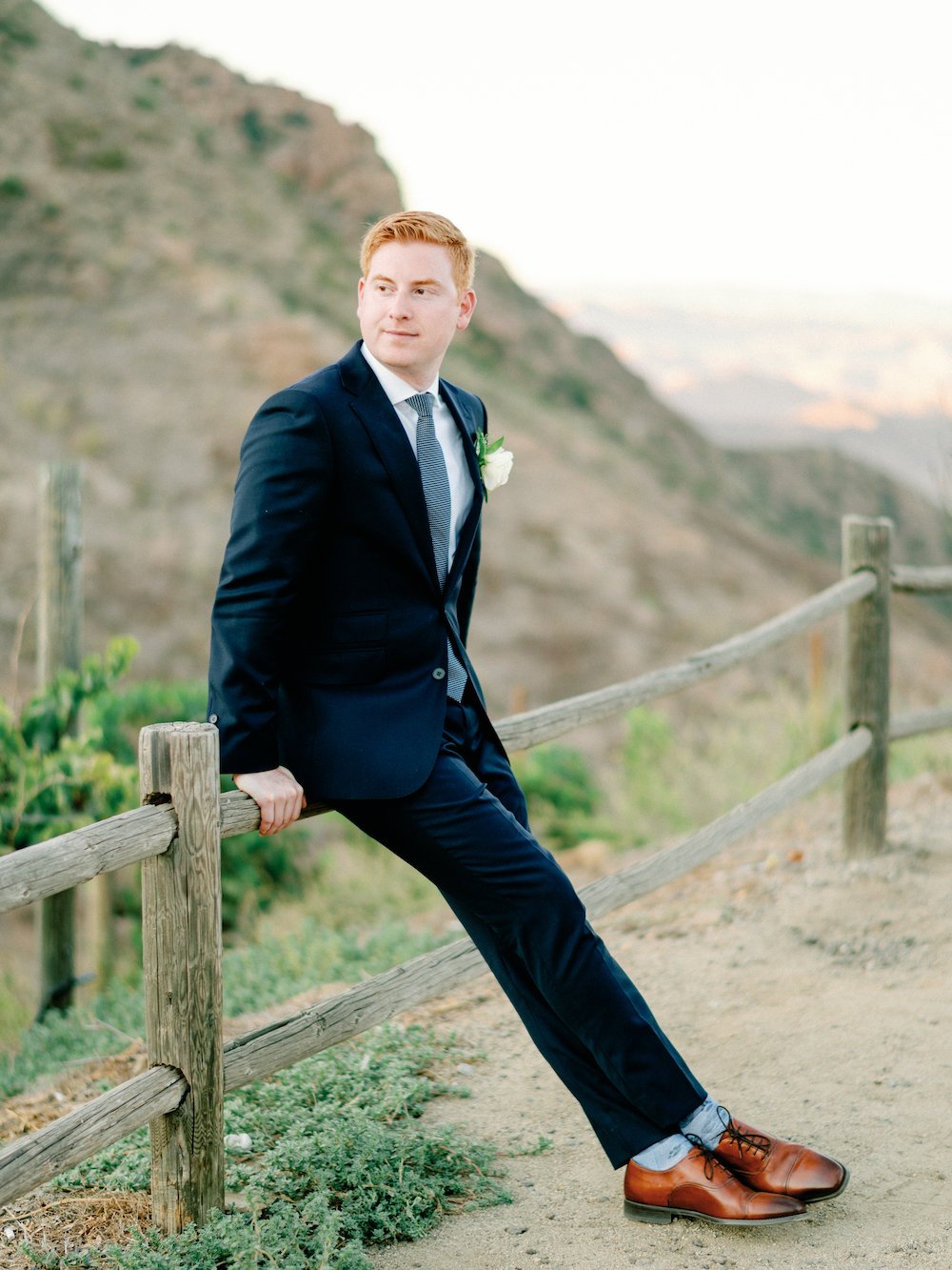 Groom portraits wearing a navy blue suite and brown shoes. 